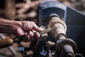 What Types of Machines Are Used in the Woodworking Industry? - Rainbow Rubber & Plastics, Inc. wood lathe machine in use to shape wood